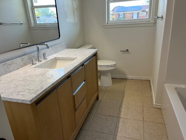 bathroom featuring vanity, a bathtub, tile patterned flooring, and toilet