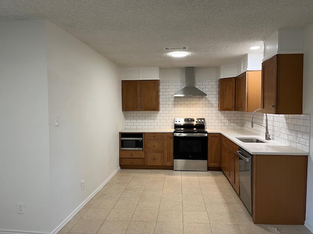 kitchen featuring tasteful backsplash, sink, stainless steel appliances, a textured ceiling, and wall chimney exhaust hood