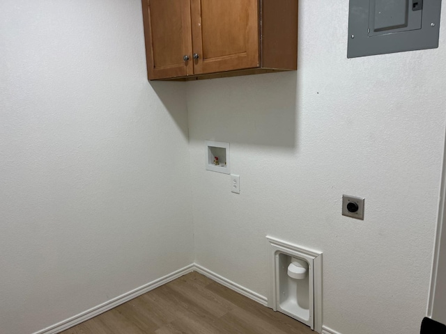 washroom with cabinets, electric panel, electric dryer hookup, washer hookup, and hardwood / wood-style floors