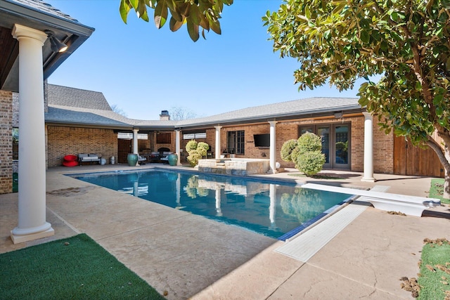 view of pool with a fenced in pool, french doors, a patio, and a diving board