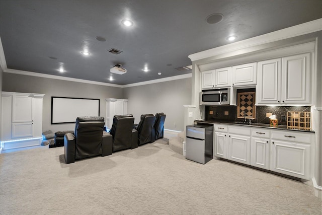 home theater with ornamental molding, recessed lighting, visible vents, and light carpet