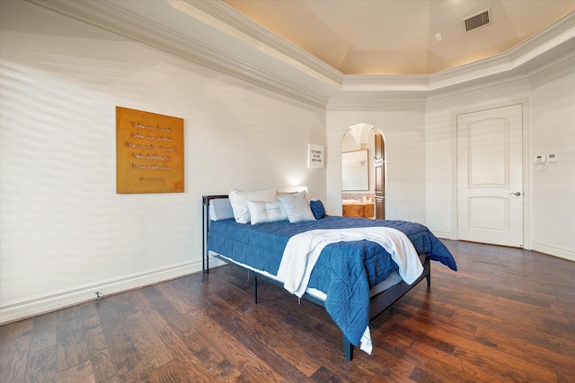 bedroom featuring visible vents, arched walkways, wood finished floors, and crown molding