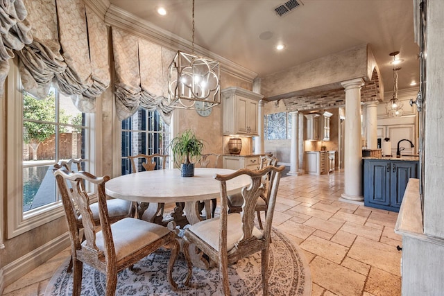 dining area featuring visible vents, ornamental molding, stone tile floors, a notable chandelier, and ornate columns