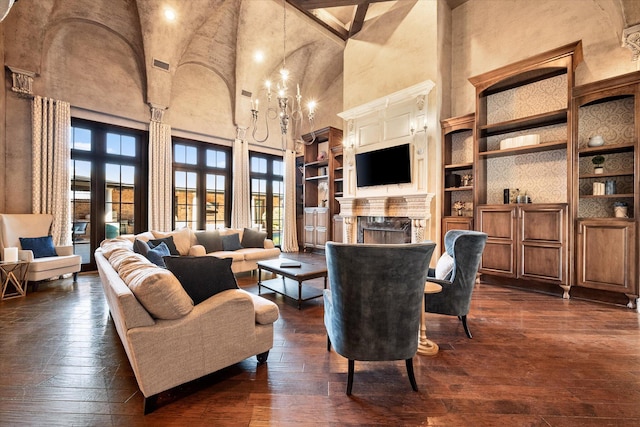 living area featuring dark wood-style floors, built in features, a fireplace, and a high ceiling