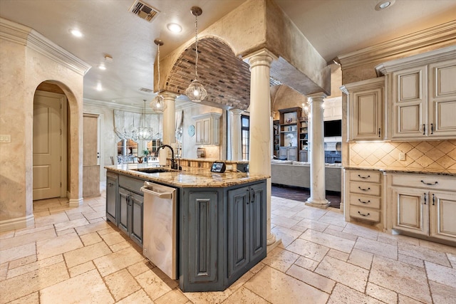 kitchen featuring stone tile floors, ornate columns, a sink, dishwasher, and cream cabinets