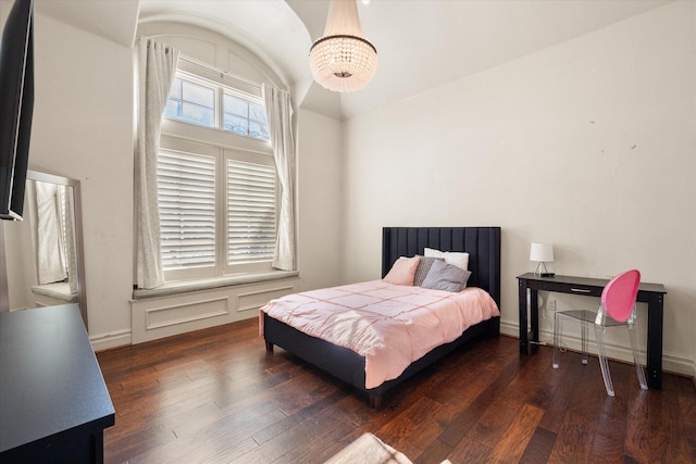 bedroom featuring hardwood / wood-style flooring, baseboards, and a chandelier