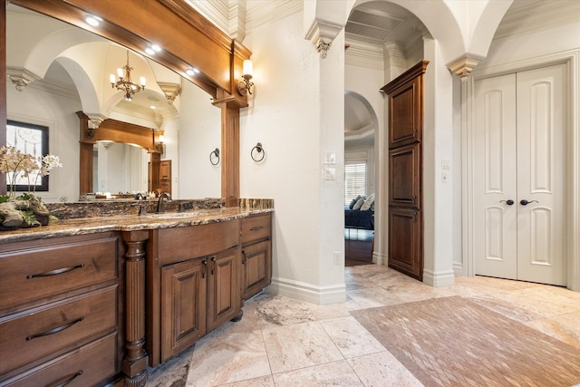 bathroom featuring ornate columns, vanity, baseboards, and ornamental molding