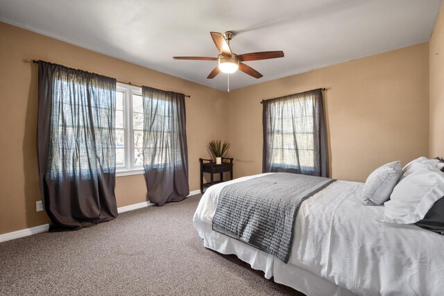 carpeted bedroom featuring ceiling fan and baseboards