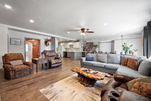 living area with recessed lighting, ceiling fan, wood finished floors, and visible vents