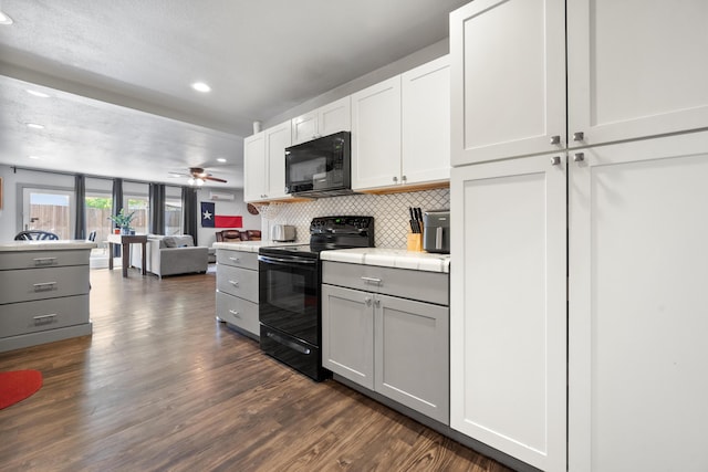 kitchen featuring black appliances, tile countertops, dark wood finished floors, and gray cabinets
