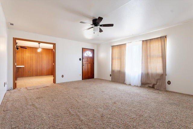 interior space featuring ceiling fan and wooden walls