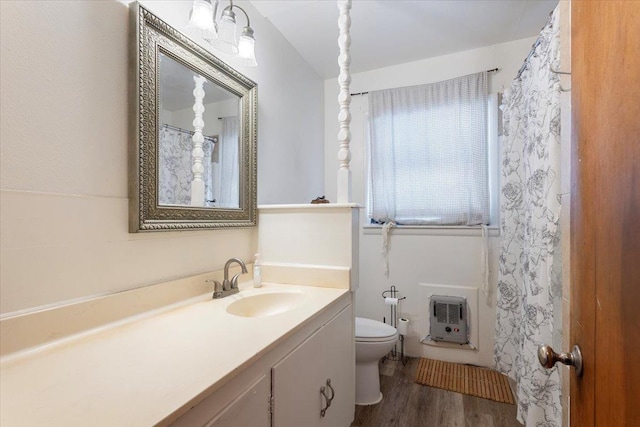 bathroom featuring hardwood / wood-style flooring, vanity, toilet, and heating unit