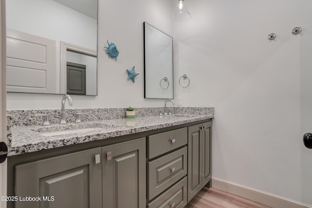 5713 116th St, Lubbock, TX 79424 - full bath with double vanity, baseboards, and wood finished floors