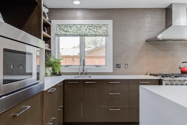 4615 11th St, Lubbock, TX 79416 - kitchen with wall chimney range hood, light countertops, dark brown cabinetry, tasteful backsplash, and stainless steel microwave