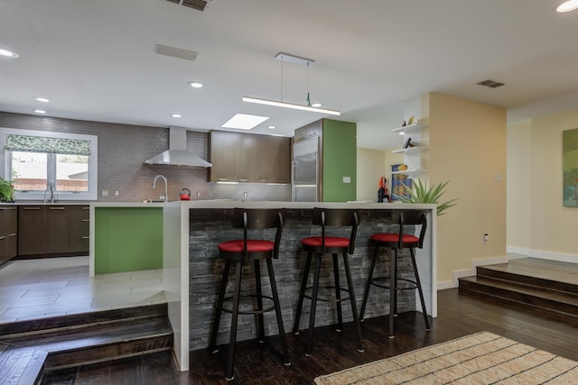 4615 11th St, Lubbock, TX 79416 - kitchen with wall chimney range hood, stainless steel built in refrigerator, modern cabinets, recessed lighting, and backsplash