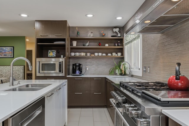 4615 11th St, Lubbock, TX 79416 - kitchen featuring wall chimney range hood, appliances with stainless steel finishes, light countertops, decorative backsplash, and recessed lighting
