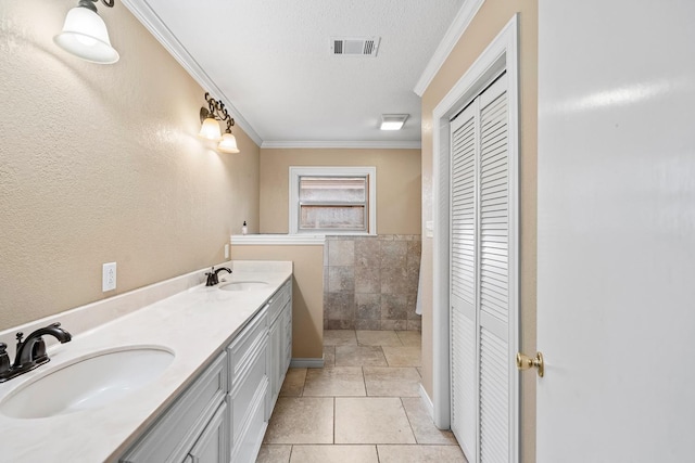 bathroom featuring tile patterned floors, crown molding, a textured ceiling, tile walls, and vanity