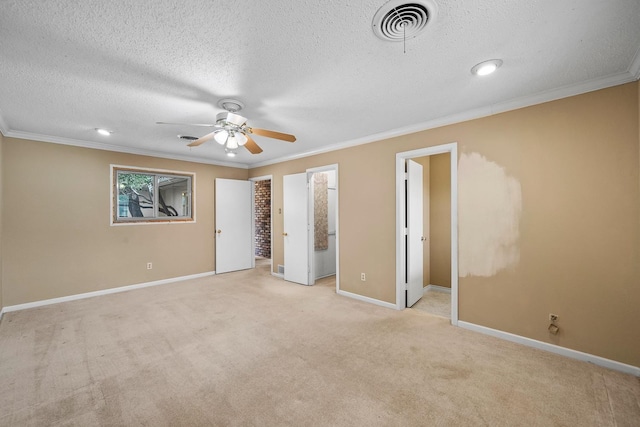 unfurnished bedroom with ornamental molding, light colored carpet, ceiling fan, and a textured ceiling