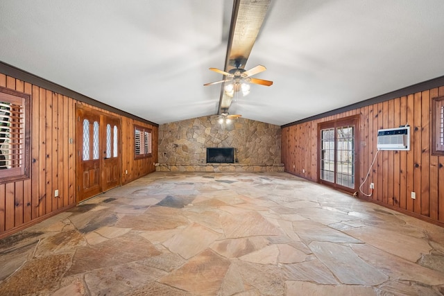 unfurnished living room with a stone fireplace, lofted ceiling with beams, a wall unit AC, and wood walls