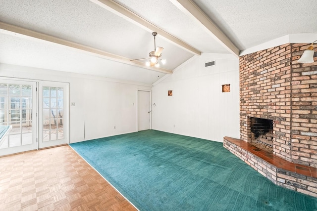 unfurnished living room with parquet flooring, a fireplace, vaulted ceiling with beams, ceiling fan, and a textured ceiling