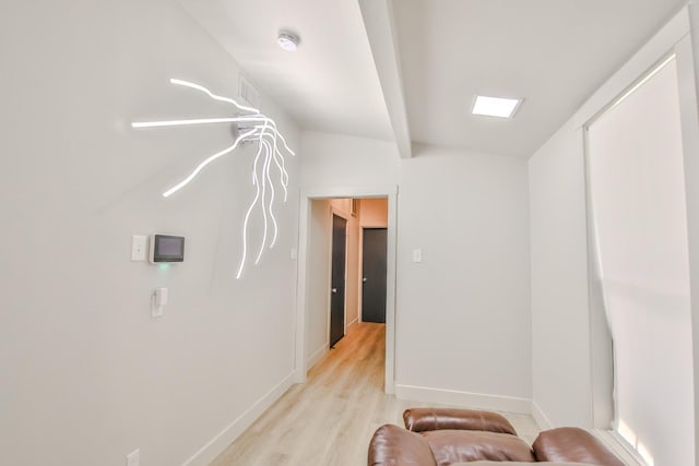 sitting room with lofted ceiling and light wood-type flooring