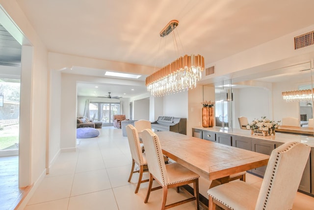 tiled dining room with a chandelier