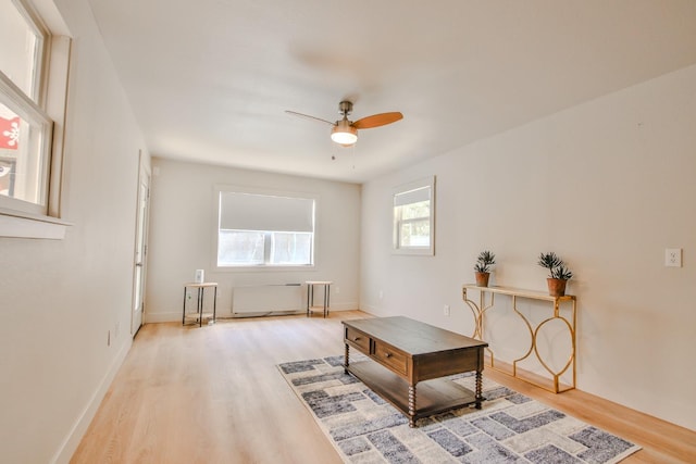 sitting room featuring radiator heating unit, hardwood / wood-style floors, and ceiling fan