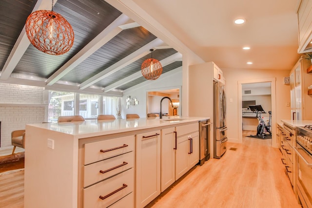 kitchen featuring pendant lighting, stainless steel fridge, sink, and vaulted ceiling with beams