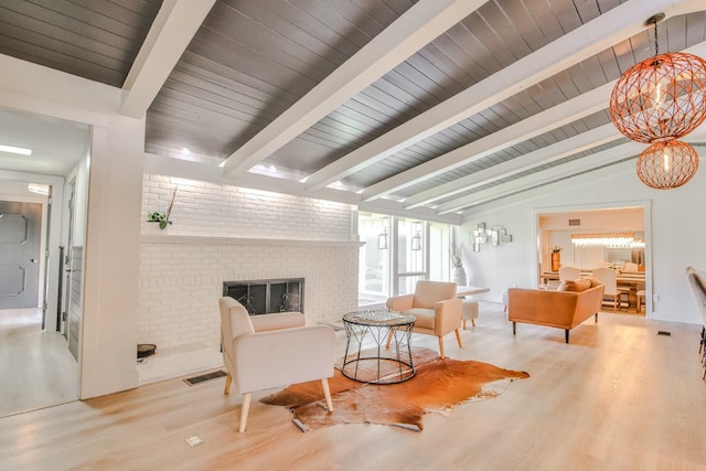 living area featuring a brick fireplace, lofted ceiling with beams, light hardwood / wood-style floors, and wooden ceiling