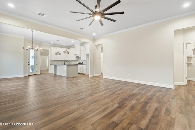 1016 N Genoa Ave, Lubbock, TX 79416 - unfurnished living room featuring ceiling fan, a chandelier, wood finished floors, recessed lighting, and ornamental molding
