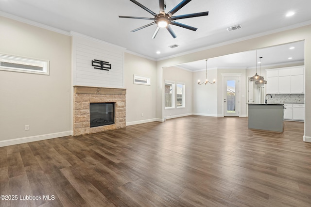 1016 N Genoa Ave, Lubbock, TX 79416 - unfurnished living room featuring a chandelier, ceiling fan, a fireplace, dark wood finished floors, and recessed lighting
