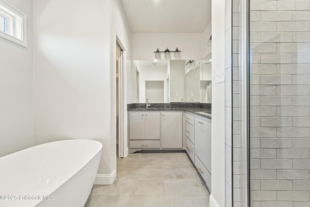 1016 N Genoa Ave, Lubbock, TX 79416 - bathroom with vanity, a freestanding bath, and tile patterned flooring