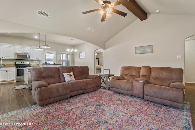 7905 Ave K, Lubbock, TX 79423 - living room with arched walkways, dark wood-type flooring, a ceiling fan, beam ceiling, and a chandelier