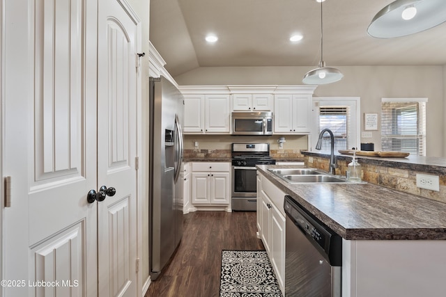 7905 Ave K, Lubbock, TX 79423 - kitchen with stainless steel appliances, dark countertops, white cabinetry, lofted ceiling, and dark wood finished floors