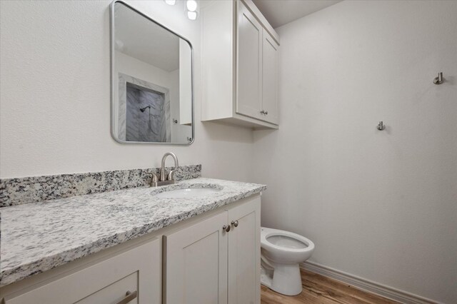 bathroom with vanity, hardwood / wood-style flooring, and toilet