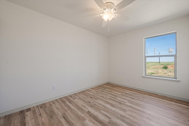 spare room with ceiling fan and light wood-type flooring