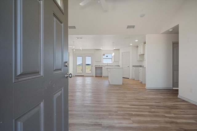 unfurnished living room featuring ceiling fan and light hardwood / wood-style floors