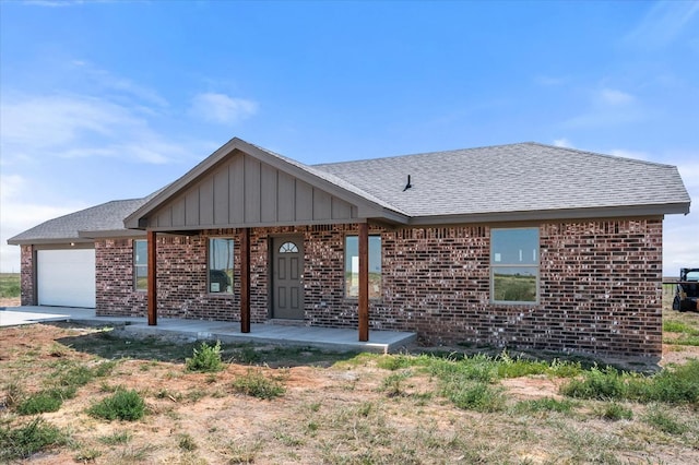 view of front of home with a garage and a patio