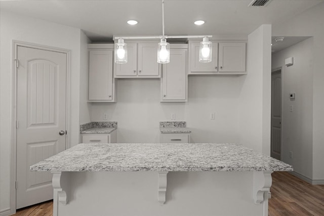 kitchen featuring white cabinetry, a center island, dark wood-type flooring, and hanging light fixtures