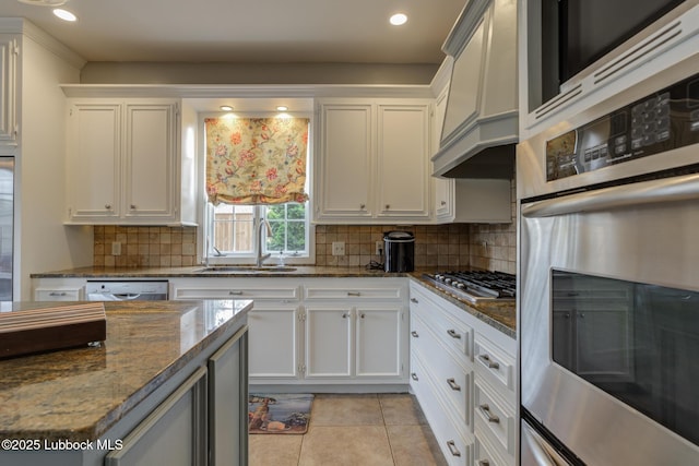 4204 89th St, Lubbock, TX 79423 - kitchen featuring stainless steel appliances, a sink, white cabinets, light tile patterned floors, and tasteful backsplash