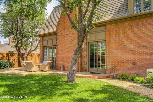 4204 89th St, Lubbock, TX 79423 - back of house featuring brick siding, a patio area, and a shingled roof