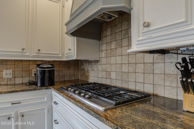 4204 89th St, Lubbock, TX 79423 - kitchen with stainless steel gas stovetop, white cabinets, backsplash, custom exhaust hood, and dark stone counters