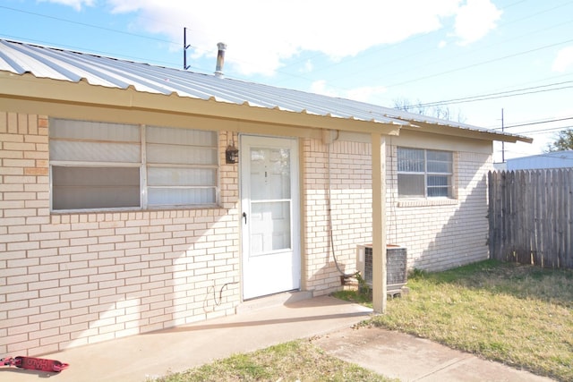 doorway to property with a yard, a patio area, and central air condition unit