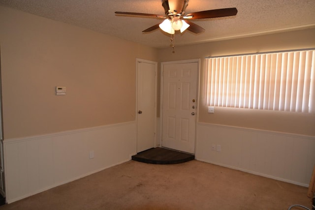 interior space with ceiling fan and a textured ceiling