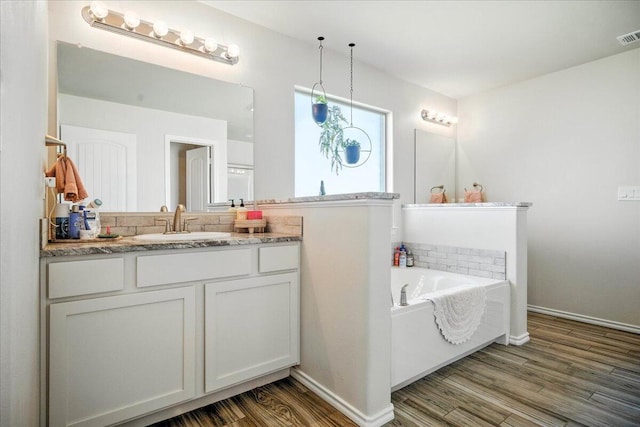 7502 103rd St, Lubbock, TX 79424 - full bath with a bath, wood finished floors, and vanity