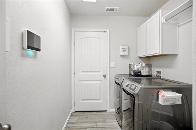 7502 103rd St, Lubbock, TX 79424 - laundry area featuring cabinet space, washing machine and clothes dryer, and light wood finished floors