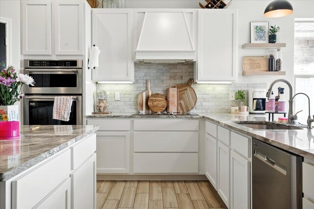 7502 103rd St, Lubbock, TX 79424 - kitchen with stainless steel appliances, open shelves, custom range hood, and white cabinetry