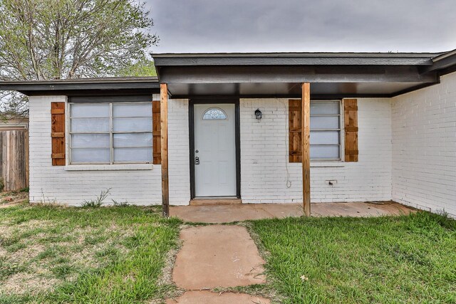 property entrance with a lawn