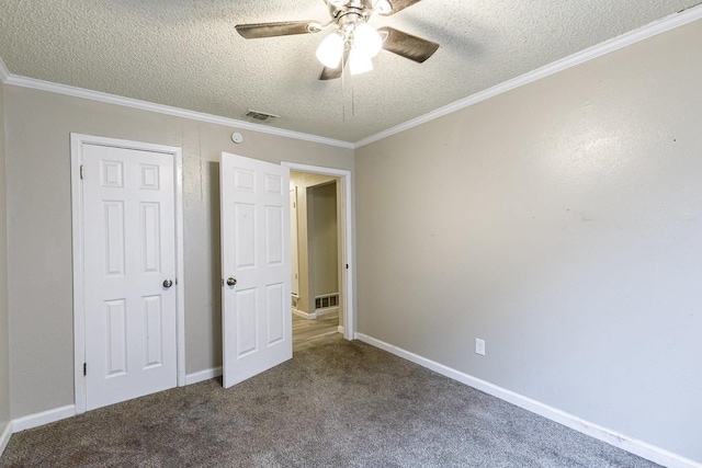 unfurnished bedroom with ceiling fan, ornamental molding, carpet flooring, and a textured ceiling