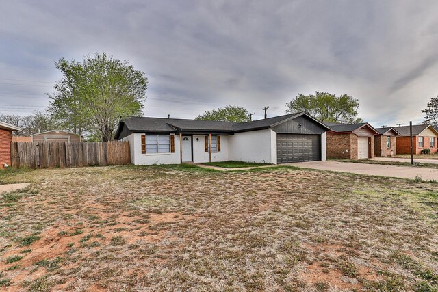 ranch-style home featuring a garage and a front yard